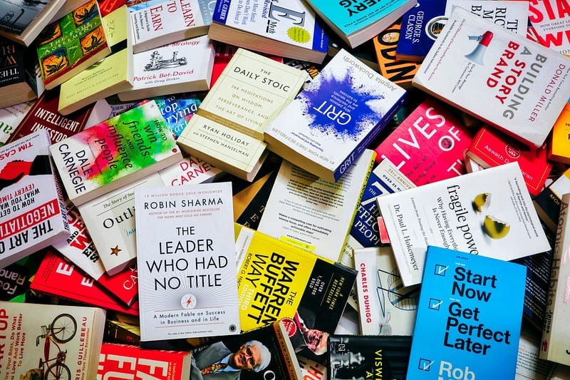 pile of self-improvement, finance, economics, business and personal growth books